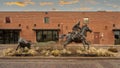 Bronze statue of a cowboy on horseback roping a steer on display at the Fort Worth Stockyards in Texas.