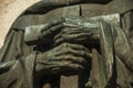 Bronze statue detail of priest hands holding a cross at Caceres