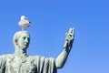 Statue of emperor Caesar Nervae August with gull on the head. Man taking selfie. Humor concept Royalty Free Stock Photo