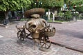 Bronze statue of a fat bucket seller on a bicycle, in the downtown