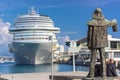 Bronze statue of a figurehead stands in front of a large vessel.