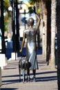Bronze statue of lady waving viewed from behind
