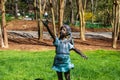A bronze statue of a little girl holding a butterfly surrounded by lush green grass, trees and plants at Gibbs Gardens