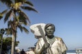 Bronze statue of Tom Jobim with white space and palm trees