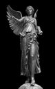 Bronze statue of a Winged Victory. Frontal view of a Statue of the goddess Nike, isolated on black background by Royalty Free Stock Photo