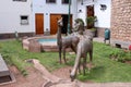 A bronze statue of a women pouring water into a fountain with two llama statues nearby in Cusco, Peru Royalty Free Stock Photo