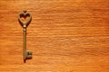 Bronze toned heart shaped key on a wooden table Royalty Free Stock Photo