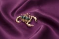 Brooch gold scorpion on red silk Royalty Free Stock Photo