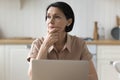 Brooding woman deep in thought sit at table with laptop Royalty Free Stock Photo