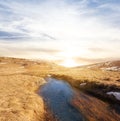 Brook flow among prairie at the sunset Royalty Free Stock Photo