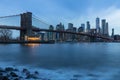 Brooklyn Bridge in Manhattan downtown with Cityscape on a foggy cloudy day at sunset New York USA Royalty Free Stock Photo