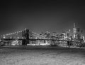 The Brooklyn Bridge at night with Manhattan skyline on background and green meadow in foreground, New York City Royalty Free Stock Photo