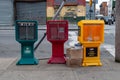 The three empty colorful newspaper boxes on sidewalk in Brooklyn street.