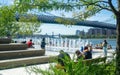 Landscape view of Domino Park`s fountain and seating steps. The East River and Williamsburg Bridge