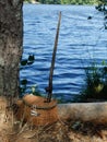 Fishing hole- Antique wooden fishing pole and small wicker basket for fishing lures Royalty Free Stock Photo