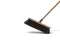 A broom with black bristles sweeps dust on a white background. Space for text. Royalty Free Stock Photo