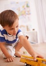 Broom broom. a cute little boy playing with a yellow toy truck in his room. Royalty Free Stock Photo
