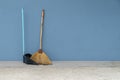 Broom and dustpan old on the blue cement wall Royalty Free Stock Photo