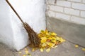 A broom and a pile of leaves in the yard of the house. Royalty Free Stock Photo