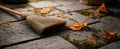 The broom resting on a cobbled path surrounded by fallen autumn leaves..AI generated image Royalty Free Stock Photo