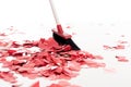 broom sweeping out heart shaped confetti