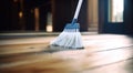 brooming a hardwood floor with white broom