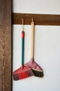 Brooms hanging on white background.