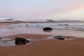 Calm beach at dawn, with snow covered hills Royalty Free Stock Photo