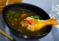 Broth with chicken leg in black bowl Royalty Free Stock Photo