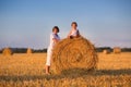 Brother and baby sister playing in a field of hay bales Royalty Free Stock Photo