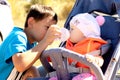 The brother gives to baby girl to drink water from a bottle in a park Royalty Free Stock Photo