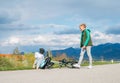 Brother helping his sister after bike falling while she doing first steps in riding. Happy childhood concept image. Kids on