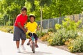 Brother helping his sister riding bicycle at park Royalty Free Stock Photo