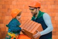 Brother helping at workshop. Bricklayer make masonry, builder work with brick layer Royalty Free Stock Photo