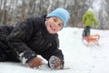 Brother lie on snow, sister pulls sleigh