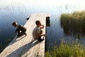 Brother playing on wooden bridge by lake Royalty Free Stock Photo