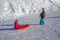 Brother pulling his sister kids toboggan sled snow. Little girl and boy enjoying sleigh ride. Child sledding. Children Royalty Free Stock Photo