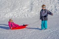 Brother pulling his sister kids toboggan sled snow. Little girl and boy enjoying sleigh ride. Child sledding. Children Royalty Free Stock Photo