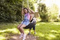 Brother Pushing Sister On Tire Swing In Garden Royalty Free Stock Photo
