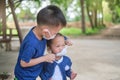 Brother putting mask on his toddler girl sister, Siblings wearing protective medical mask in public area, New normal lifestyle