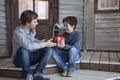 Brother receives a gift on the porch of the veranda