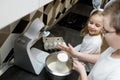 Brother sifting flour, preparing dough for Easter cookies, cross buns. Sister in bunny ears intrested looking at process Royalty Free Stock Photo