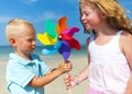 Brother sister blowing windmill beach Concept Royalty Free Stock Photo