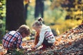 Brother and sister camping in autumn forest. Children pick acorns from oak trees. Little boy and girl friends have fun Royalty Free Stock Photo