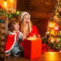 Brother and sister celebrate Christmas or New Year. Woman and the little boy are excited about something. Christmas tree