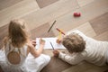 Brother and sister drawing with pencils on sheet in room Royalty Free Stock Photo