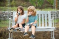 Brother and sister drink smoothie, kids summer cocktail outside. Little boy and girl working in the garden. Two happy Royalty Free Stock Photo