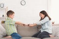 Brother and sister fighting over remote control at home Royalty Free Stock Photo