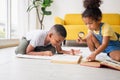 Brother and sister finding a word in book with magnifier on the floor, Happy children playing in the living room Royalty Free Stock Photo