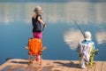 Brother and sister are fishing on a wooden pier Royalty Free Stock Photo